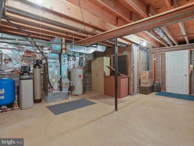  - unfinished below grade area featuring electric water heater, a water pressure tank, a water softener, and heating unit