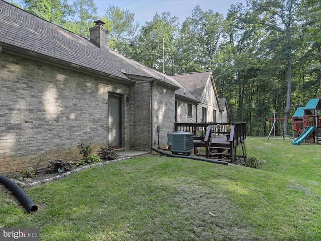  - view of grassy yard with a playground and a wooden deck
