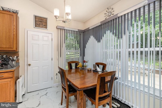 dining space with light marble finish flooring, plenty of natural light, a chandelier, radiator, and vaulted ceiling