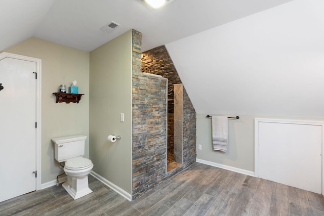 27 Black Walnut Ln, Nellysford, VA 22958 - bathroom featuring wood finished floors, vaulted ceiling, toilet, tiled shower, and baseboards