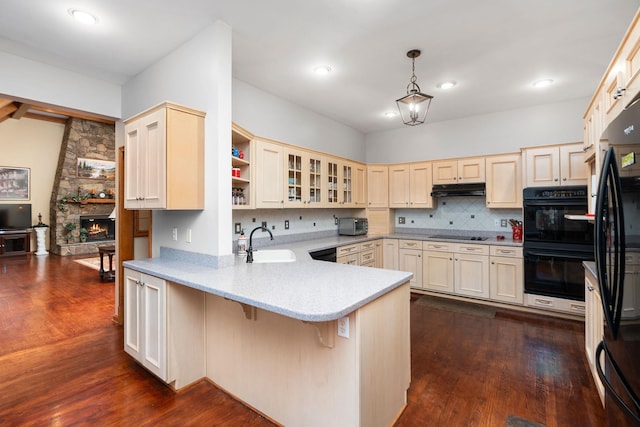 27 Black Walnut Ln, Nellysford, VA 22958 - kitchen featuring black appliances, a peninsula, under cabinet range hood, dark wood finished floors, and tasteful backsplash