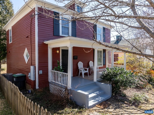 view of front of property featuring covered porch and fence