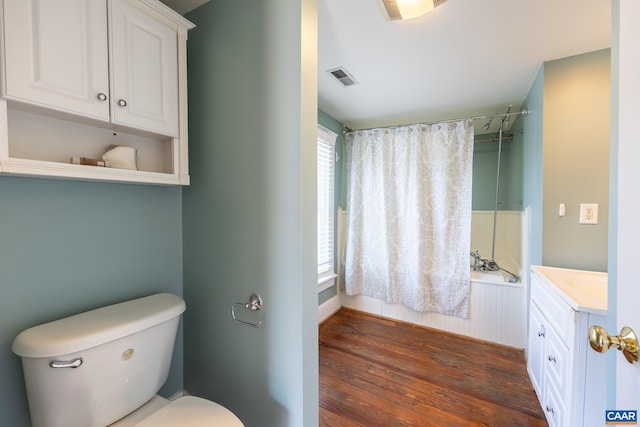 bathroom with toilet, shower / bath combination, visible vents, vanity, and hardwood / wood-style flooring