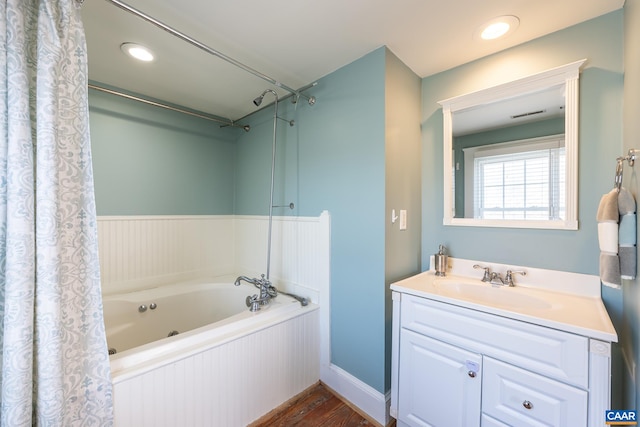 bathroom with wood finished floors, visible vents, a whirlpool tub, and vanity