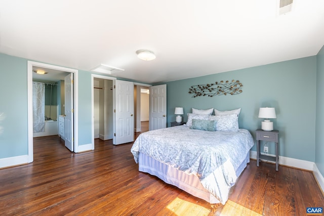 bedroom with a closet, attic access, baseboards, visible vents, and wood finished floors