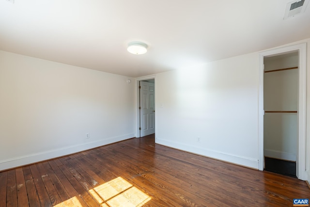unfurnished bedroom with baseboards, hardwood / wood-style floors, visible vents, and a closet
