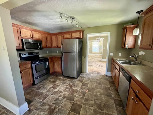 1112 Butler St, Staunton, VA 24401 - kitchen featuring appliances with stainless steel finishes, a sink, baseboards, brown cabinetry, and a textured ceiling