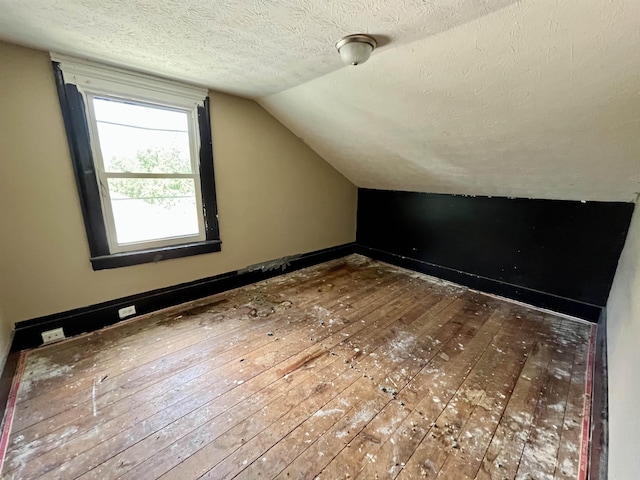 1112 Butler St, Staunton, VA 24401 - bonus room featuring hardwood / wood-style flooring, vaulted ceiling, and a textured ceiling