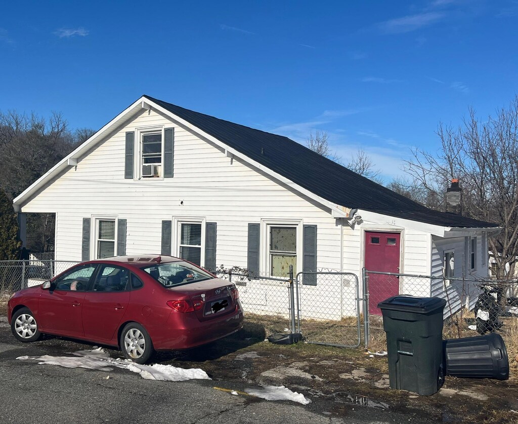 view of front of home with a chimney and fence