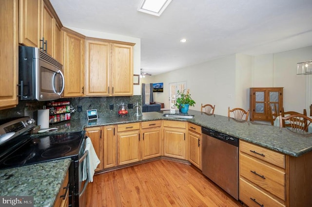 9920 Post Oak Rd, Spotsylvania, VA 22551 - kitchen featuring stainless steel appliances, a peninsula, light wood-style flooring, tasteful backsplash, and dark stone countertops