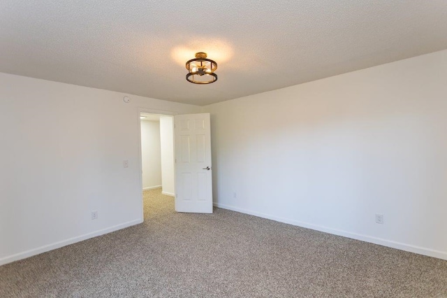 carpeted spare room with a textured ceiling