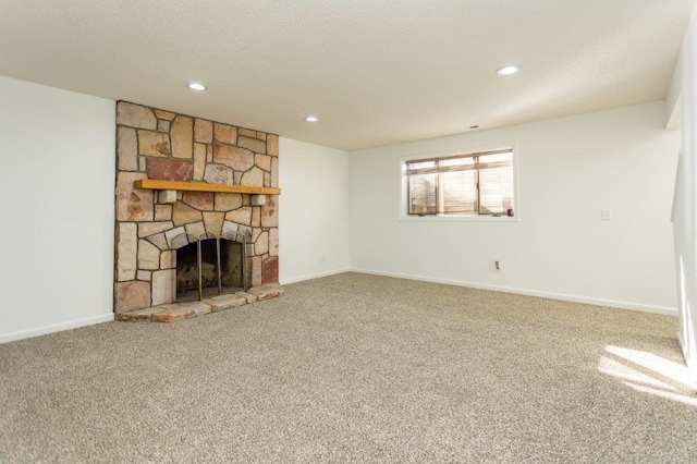 unfurnished living room with a stone fireplace, carpet flooring, and a textured ceiling