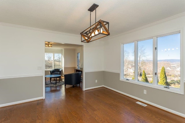 spare room featuring dark wood-type flooring, crown molding, and a textured ceiling