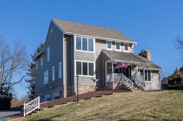 view of front facade featuring a garage, a front lawn, and a porch