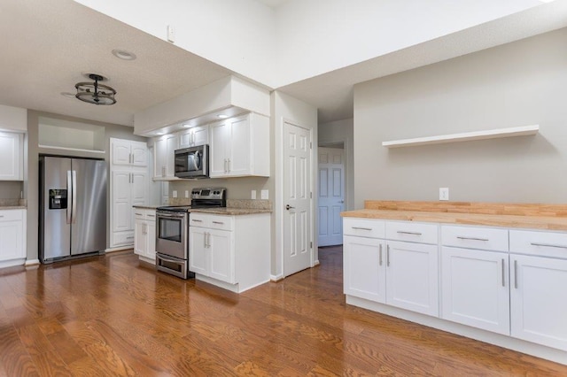 kitchen with white cabinetry, appliances with stainless steel finishes, and wood counters