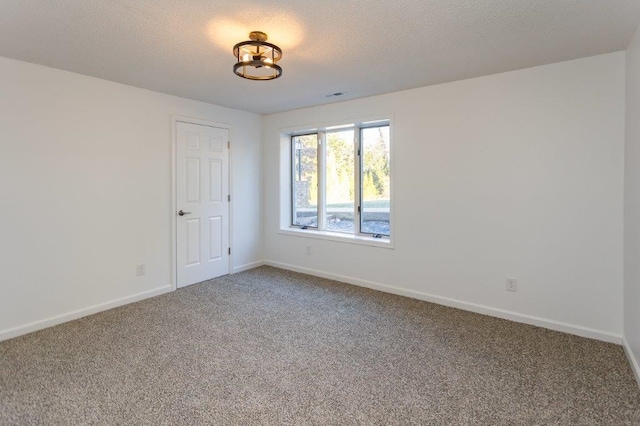 unfurnished room featuring carpet floors and a textured ceiling