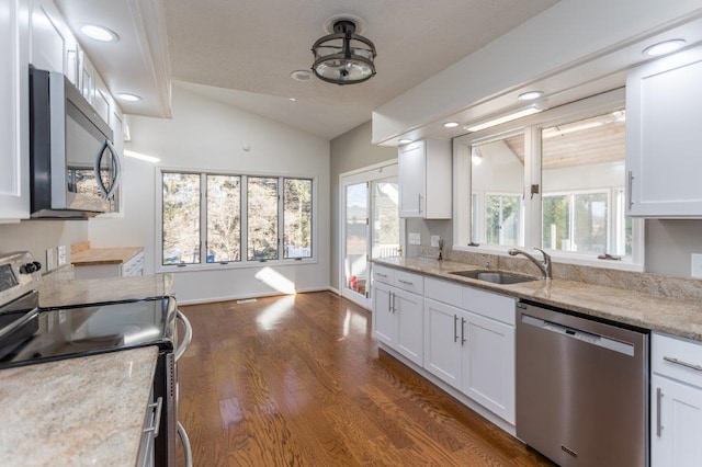 kitchen featuring white cabinetry, appliances with stainless steel finishes, sink, and lofted ceiling