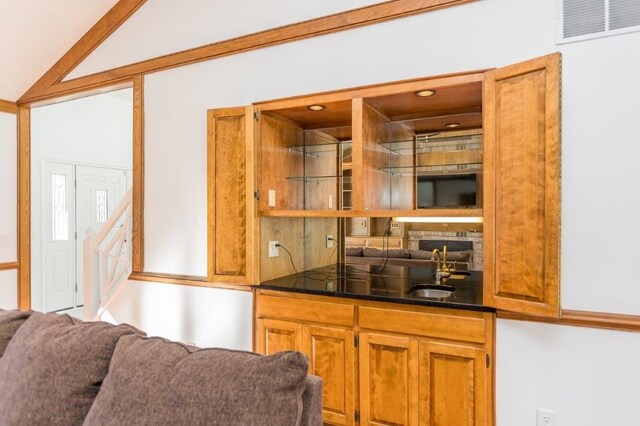 bar featuring lofted ceiling and sink