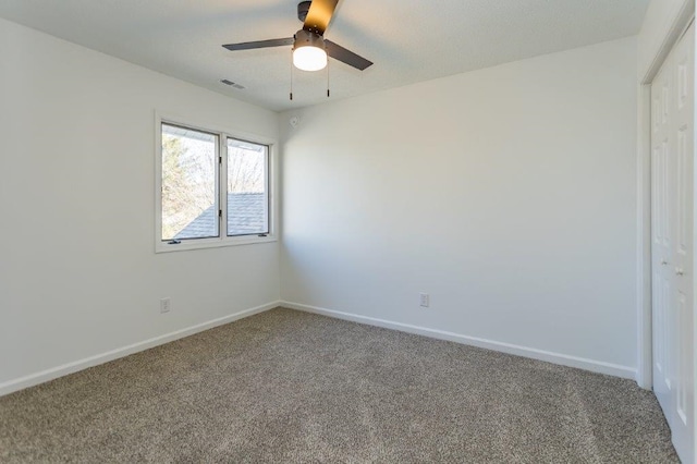 carpeted spare room featuring ceiling fan