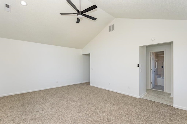 carpeted spare room featuring high vaulted ceiling and ceiling fan