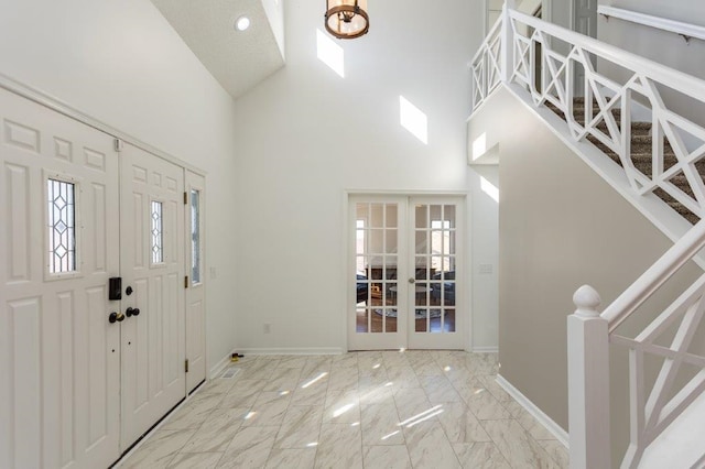 entrance foyer featuring a towering ceiling and french doors