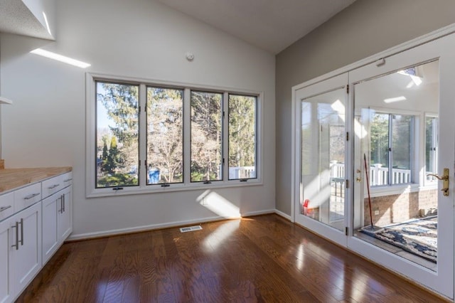 interior space featuring lofted ceiling and dark wood-type flooring