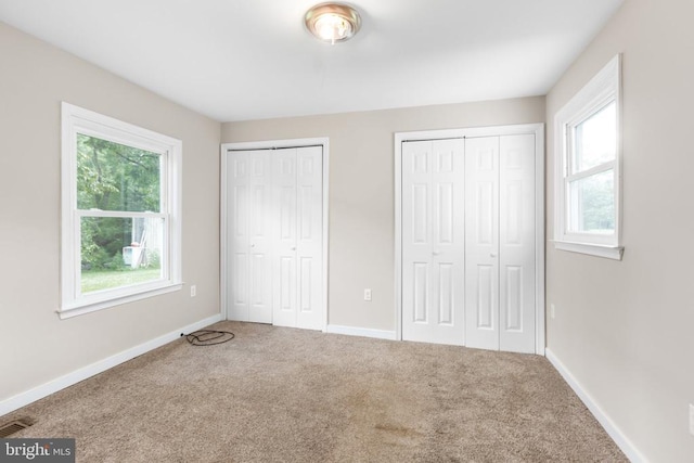308 Virginia Ave, Mineral, VA 23117 - unfurnished bedroom featuring multiple windows, multiple closets, and carpet