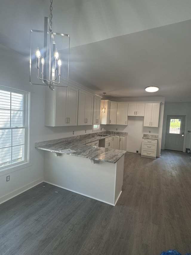 1526 2nd St, Waynesboro, VA 22980 - kitchen featuring a peninsula, light stone countertops, a chandelier, and dark wood-style floors