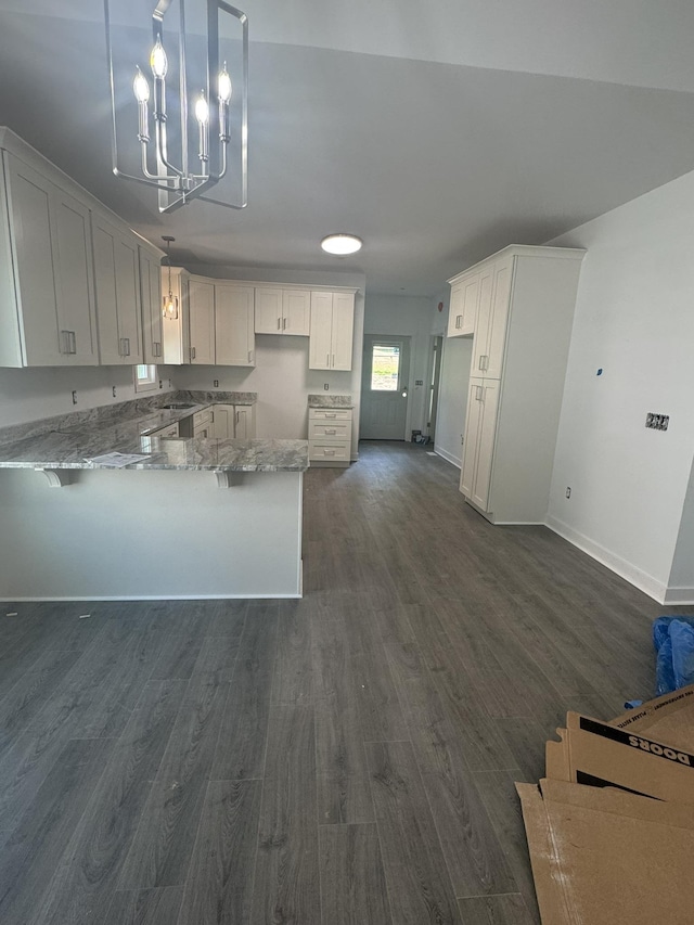 1526 2nd St, Waynesboro, VA 22980 - kitchen featuring a peninsula, light stone countertops, dark wood-style floors, a chandelier, and white cabinetry