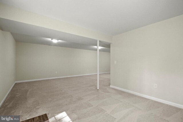 finished basement featuring light colored carpet and baseboards