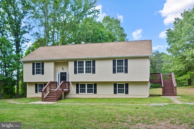 bi-level home with stairs, a front lawn, and a wooden deck