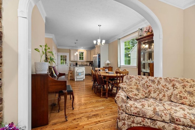 117 Villa View Dr, Staunton, VA 24401 - living area featuring crown molding, light wood-style flooring, a chandelier, and arched walkways