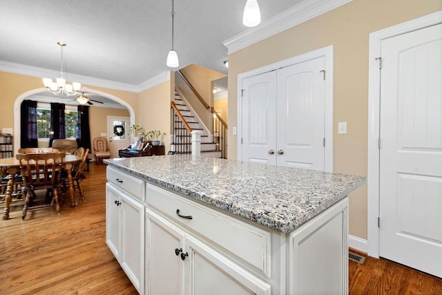 117 Villa View Dr, Staunton, VA 24401 - kitchen featuring arched walkways, crown molding, light wood-type flooring, a chandelier, and white cabinetry