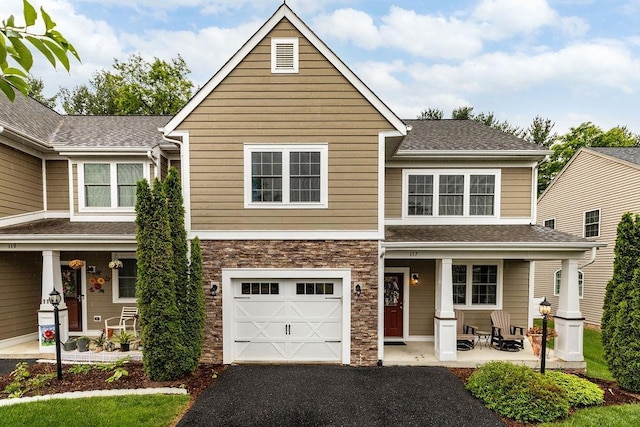 117 Villa View Dr, Staunton, VA 24401 - view of front facade featuring covered porch, a garage, driveway, stone siding, and a shingled roof