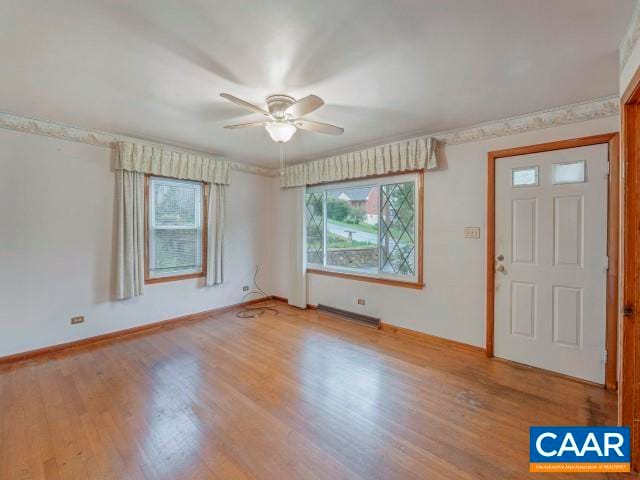 interior space featuring wood finished floors, baseboards, and ceiling fan