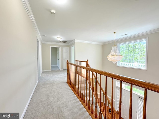 hall featuring an upstairs landing, crown molding, light colored carpet, baseboards, and a chandelier
