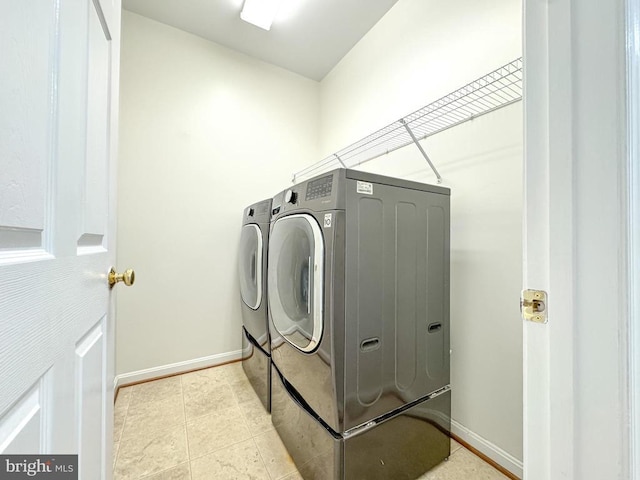 laundry room with washer and clothes dryer and baseboards