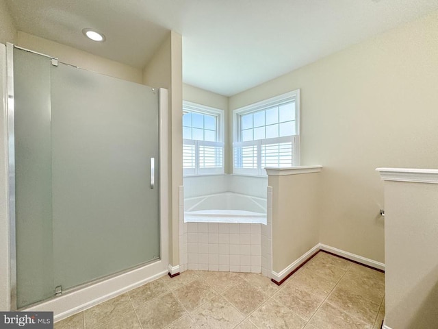 bathroom featuring a shower stall, a bath, baseboards, and tile patterned flooring