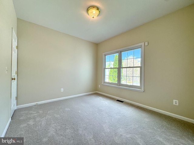 spare room featuring baseboards and carpet
