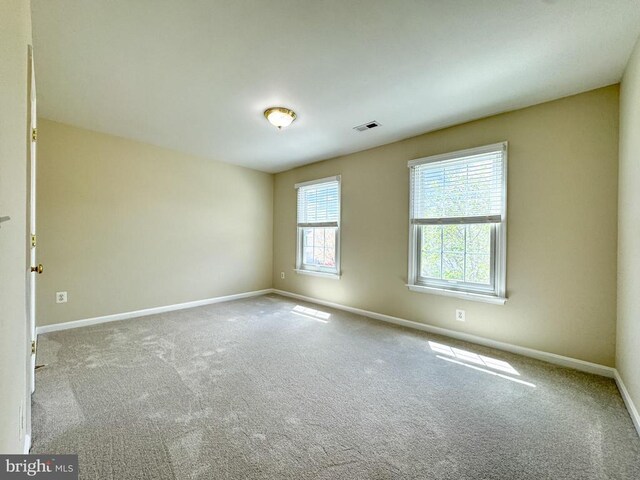 carpeted spare room featuring baseboards