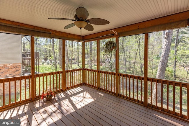 unfurnished sunroom with ceiling fan