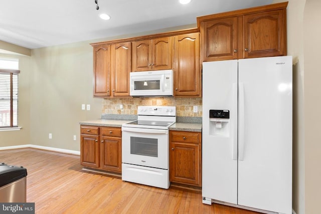 kitchen featuring white appliances, tasteful backsplash, light wood finished floors, brown cabinetry, and recessed lighting