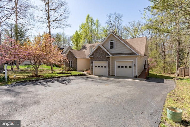 view of front of property featuring asphalt driveway, a garage, and stone siding