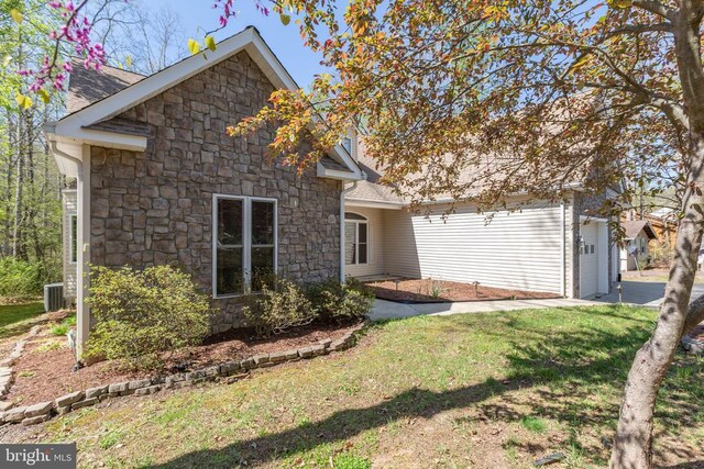 108 Monroe St, Locust Grove, VA 22508 - back of house with stone siding, an attached garage, and a lawn