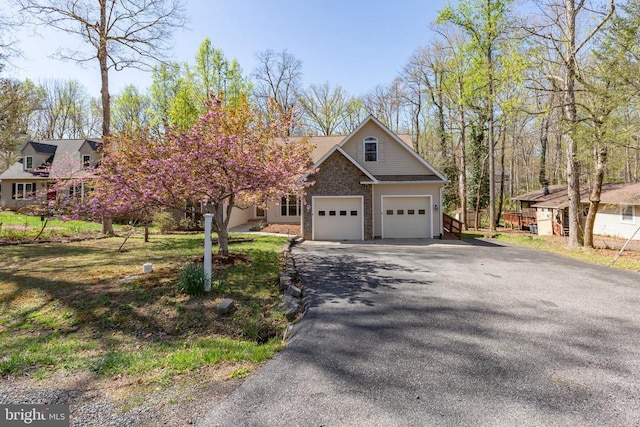 view of front of home featuring driveway, a garage, and stone siding