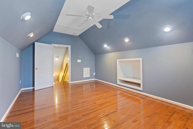 bonus room featuring lofted ceiling, wood finished floors, ceiling fan, and baseboards