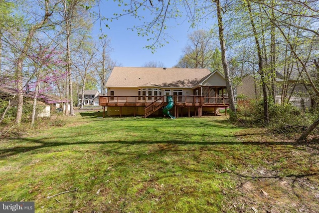 rear view of house featuring a deck, a sunroom, a yard, and stairway