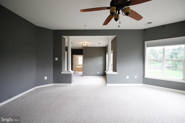  - carpeted spare room with decorative columns and a ceiling fan