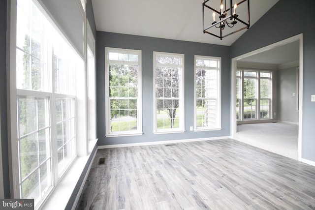  - unfurnished sunroom featuring vaulted ceiling, a chandelier, and healthy amount of natural light