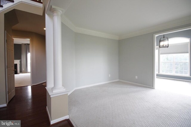 - empty room featuring ornate columns, ornamental molding, a fireplace, and a chandelier